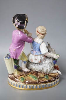 A 19th century Meissen figure group of a boy with a pipe, a girl with a grape and a goat, crossed swords in blue, incise letters and numbers. 15cm